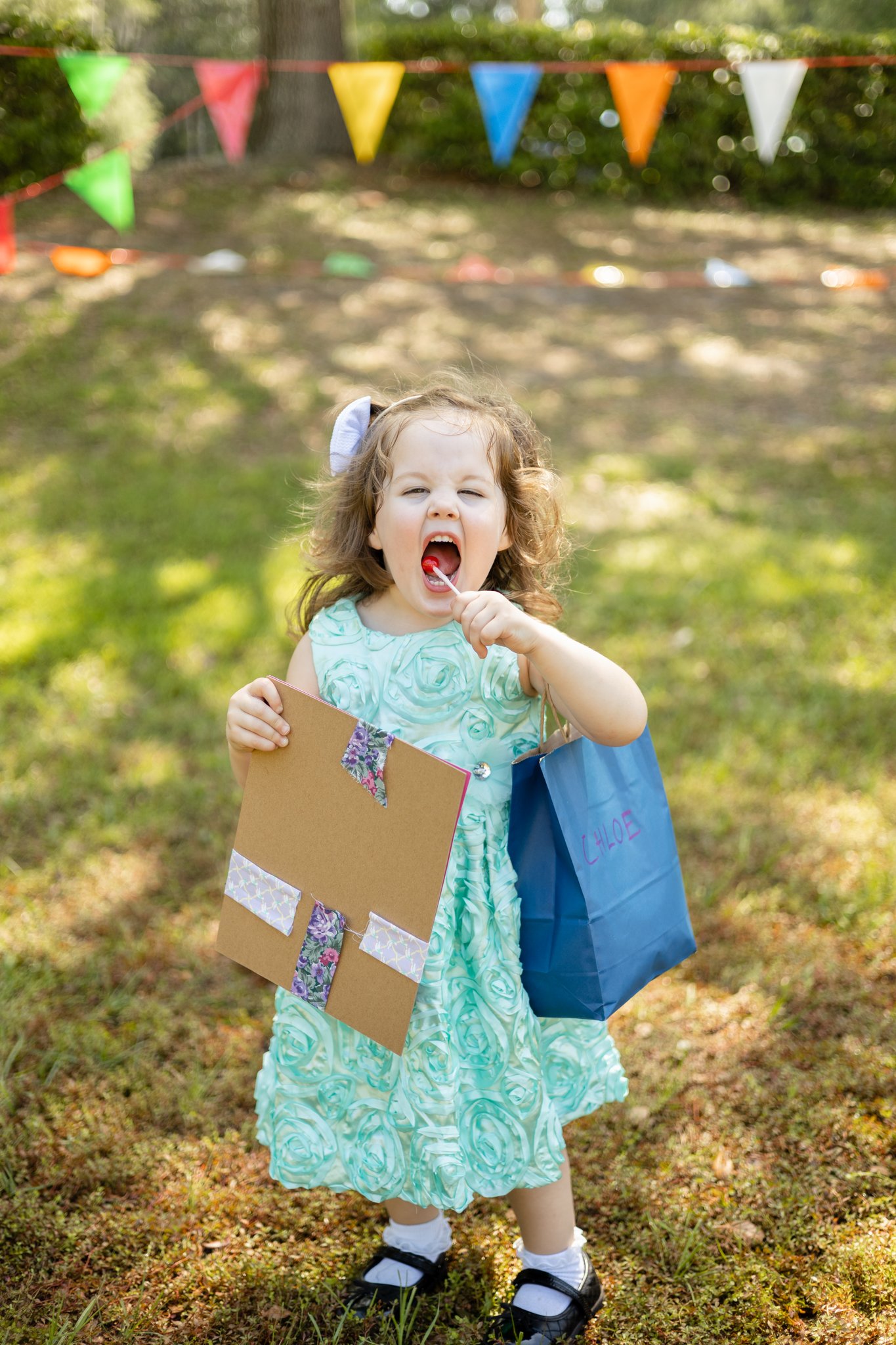 young girl eating a sucker outside.