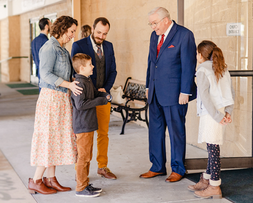 Pastor greeting people in church.