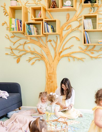 children's worker reading to toddler girls